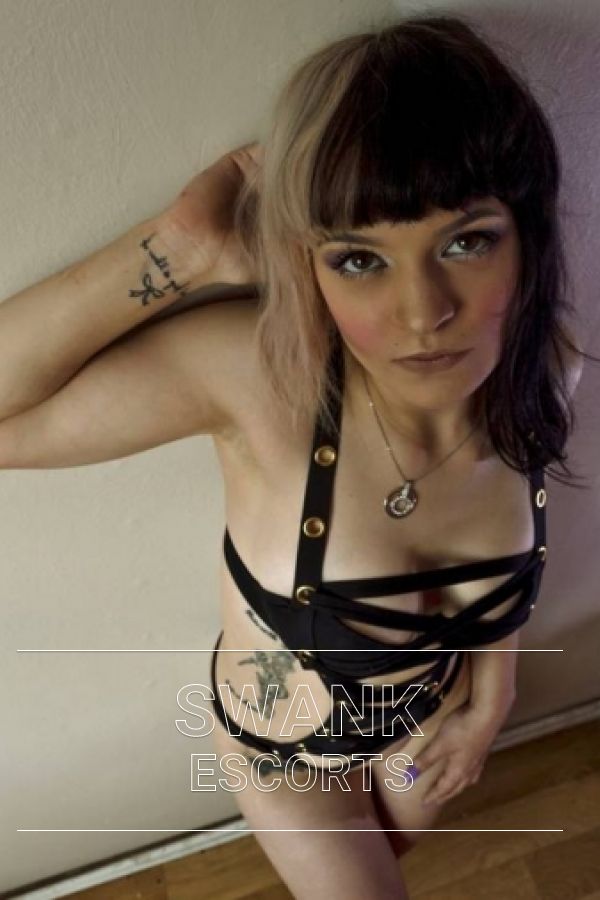 Bambii in tight black leather looking up at the camera