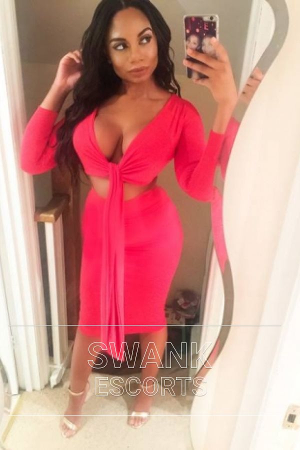 Skye taking a selfie in a red top and dress showing off her figure
